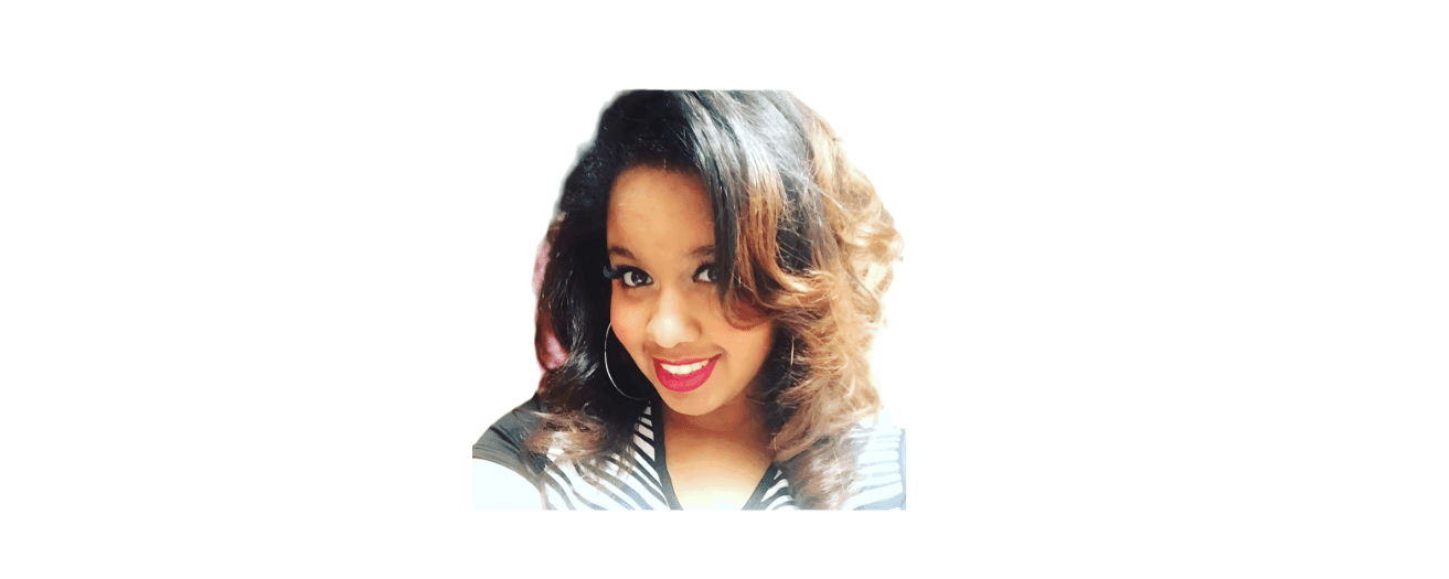 Smiling woman with wavy hair wearing hoop earrings and a striped top.